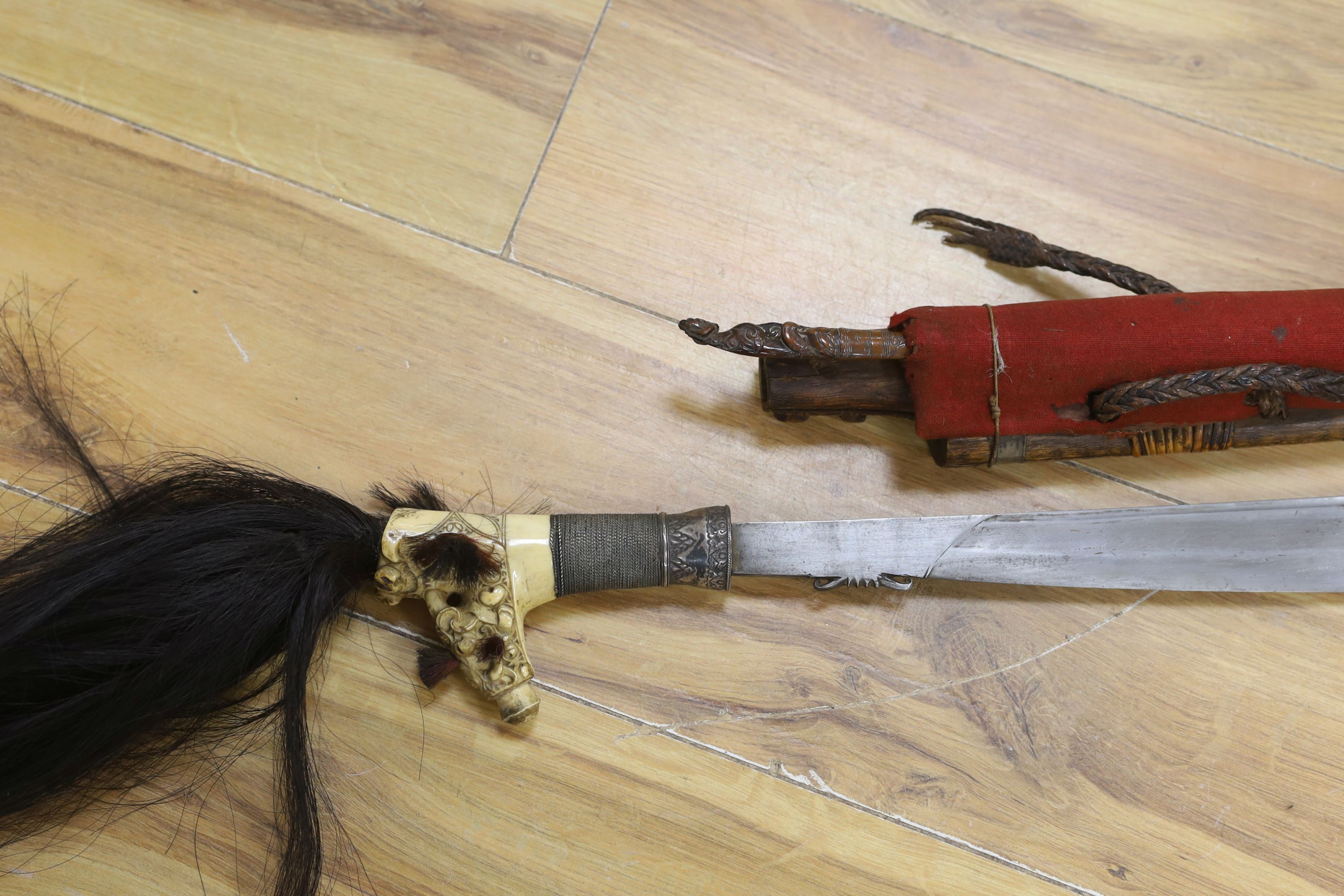 A Borneo 'headhunter's sword', a bone carving and feather swot (3), sword 77 cm long